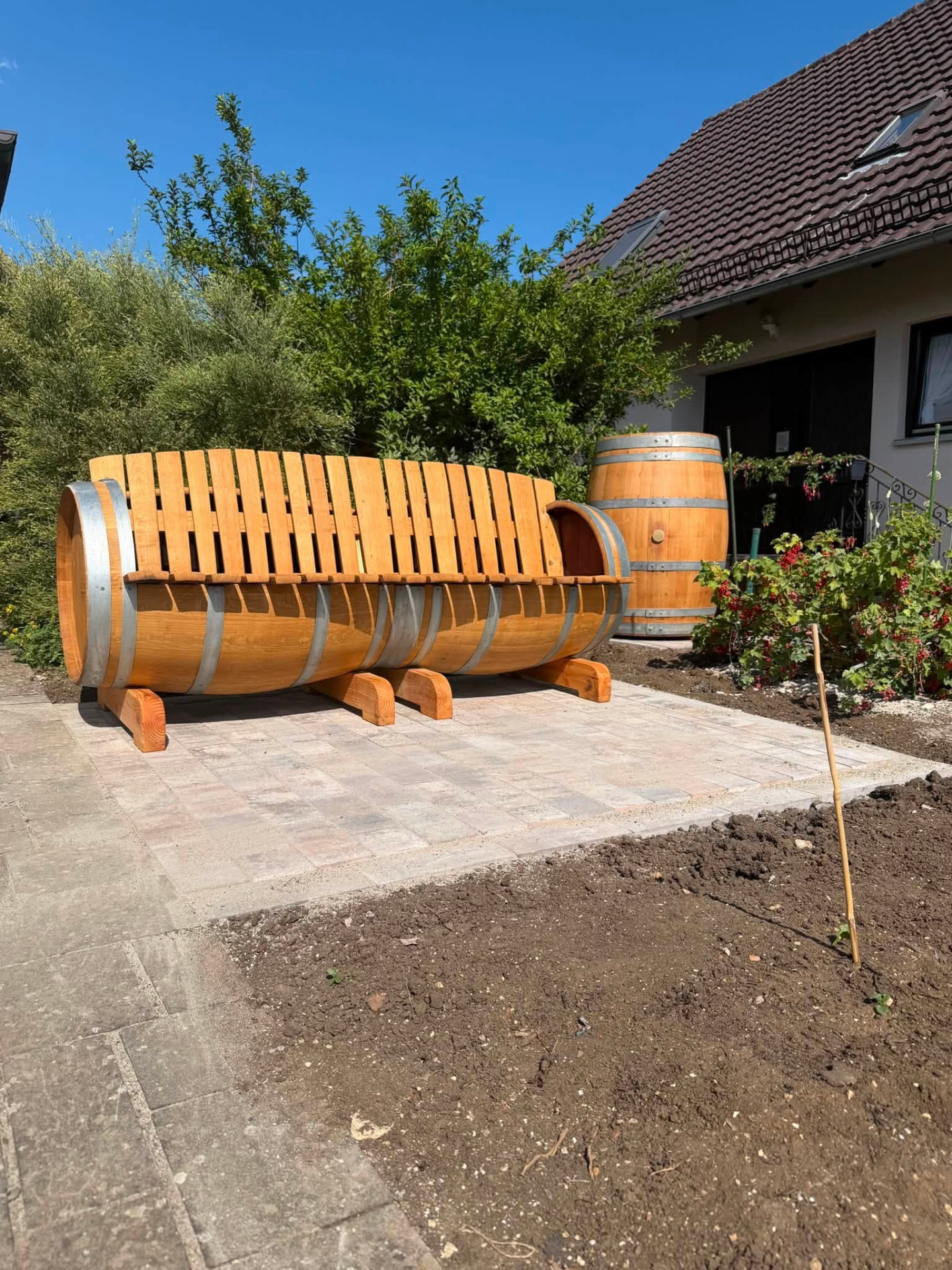 Gepflasterte Sitzfläche mit Weinfass-Bank in einem Privatgarten bei Nördlingen