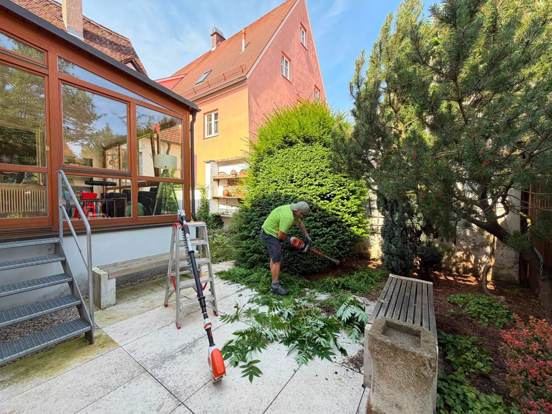 Mitarbeiter von Garten Schmalzried beim Heckenschnitt in einem Innenhof